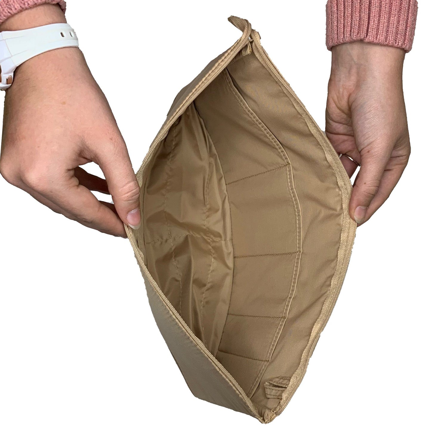 Hands holding an open, empty Purse Bling Slim Purse Organizer Insert with Zipper - Extra Jumbo, in beige, ideal for organizing your purse.
